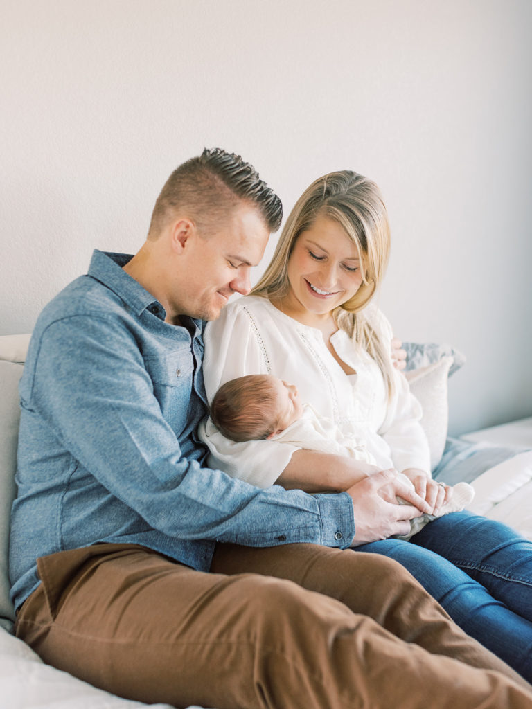 Modern denver newborn session mom and dad holding abby in bedroom 
