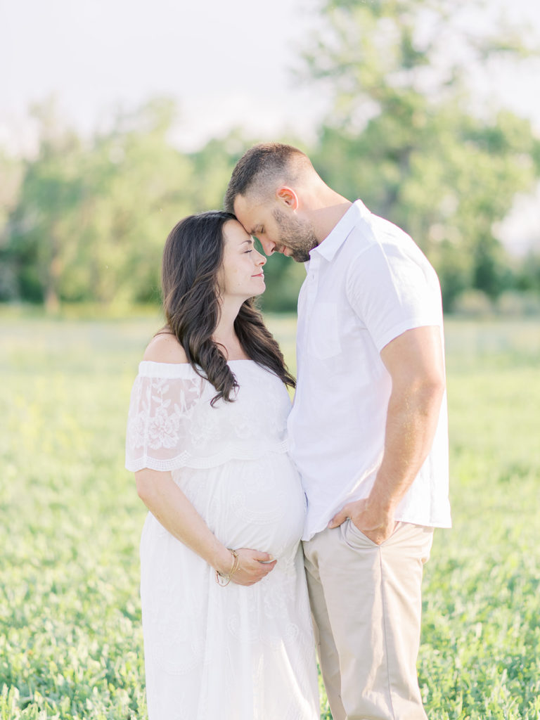 mom and dad holding baby belly during their Littleton maternity session